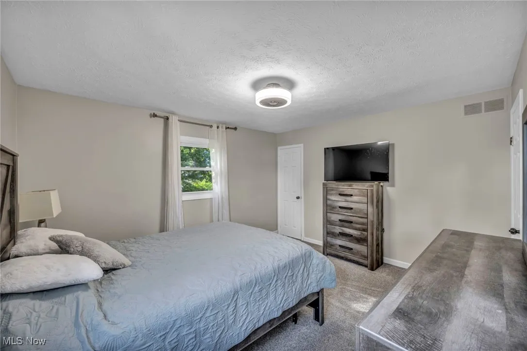Bedroom featuring carpet floors and a textured ceiling