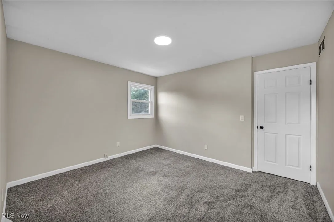 Empty room featuring carpet and baseboards