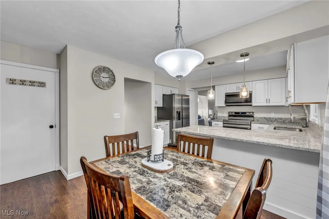 Dining space featuring dark wood-type flooring and baseboards