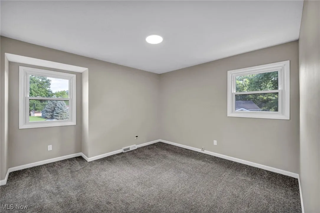 Carpeted spare room with baseboards