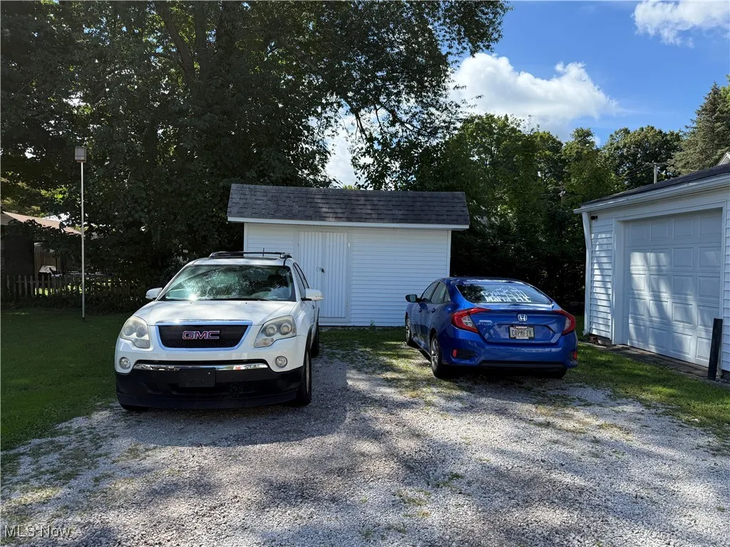 View of car parking featuring gravel driveway