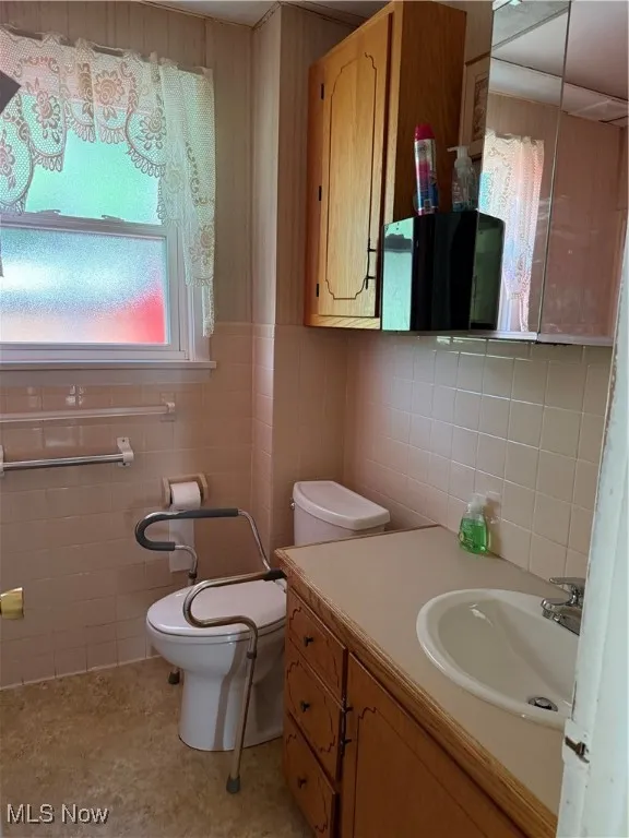 Bathroom featuring vanity and tile walls