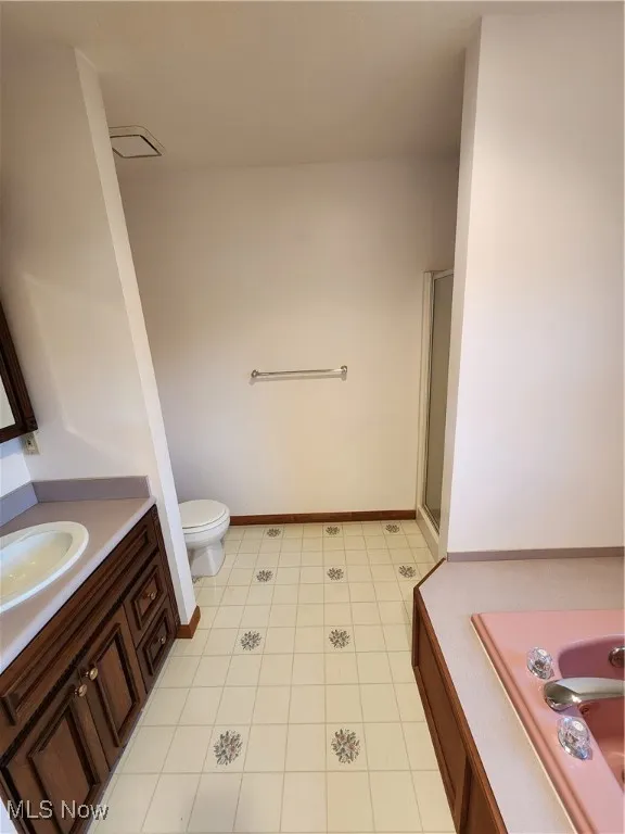 Master bathroom featuring vanity, a shower stall, and light tile floor