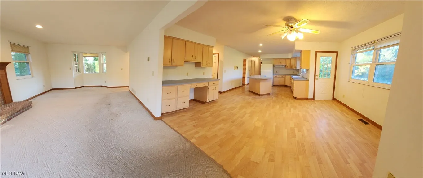 Kitchen featuring built in study area, light countertops, ceiling fan, recessed lighting, and Pergo light wood-style floors