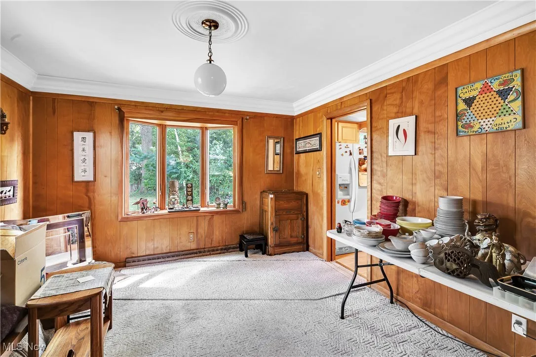 Office featuring wood walls, ornamental molding, carpet flooring, and a baseboard radiator