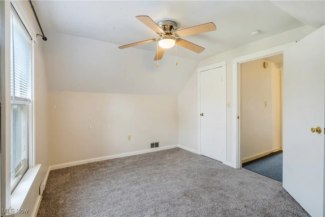 Bonus room with vaulted ceiling, carpet flooring, and ceiling fan