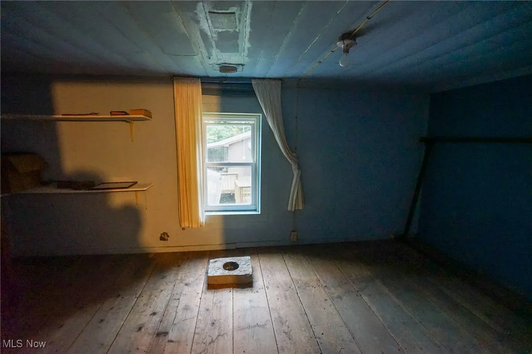 Unfurnished bedroom featuring hardwood / wood-style floors and baseboards