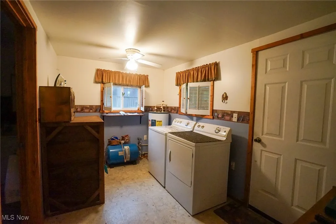 Laundry room with independent washer and dryer, light flooring, ceiling fan, and water heater