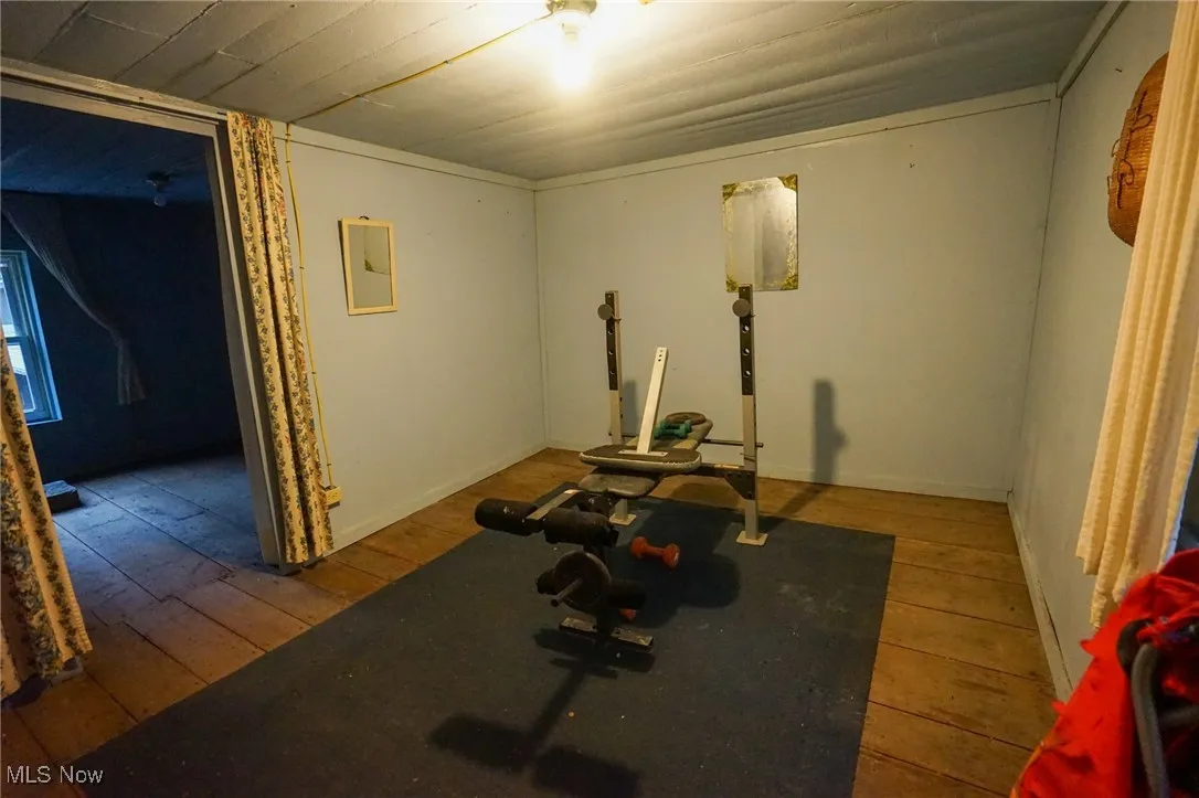 Exercise area with hardwood / wood-style flooring and baseboards