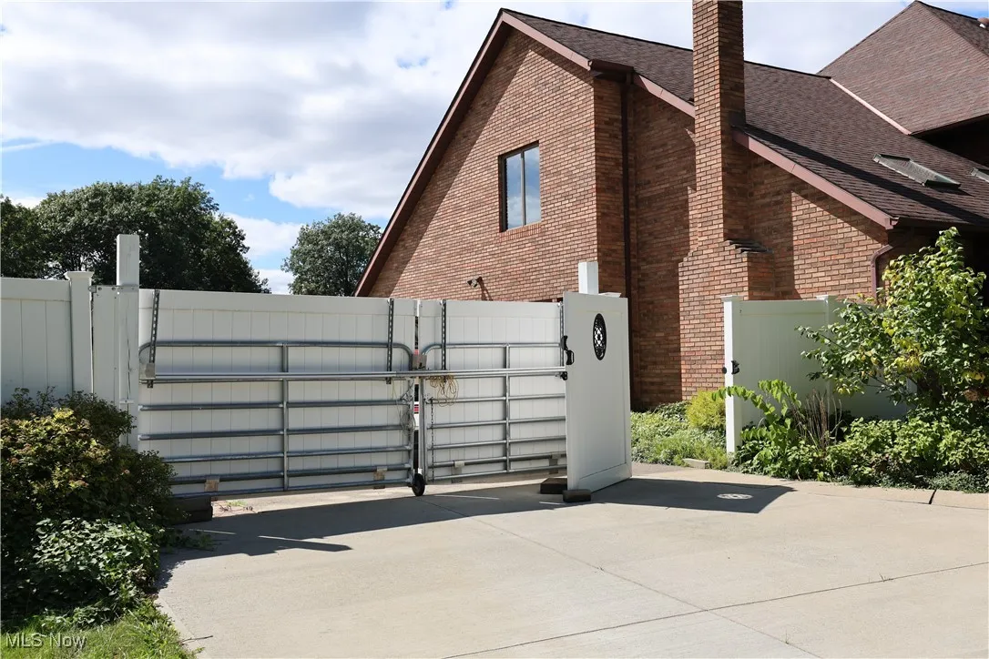 View of gate and backyard concrete pad for boat or recreational vehicle storage