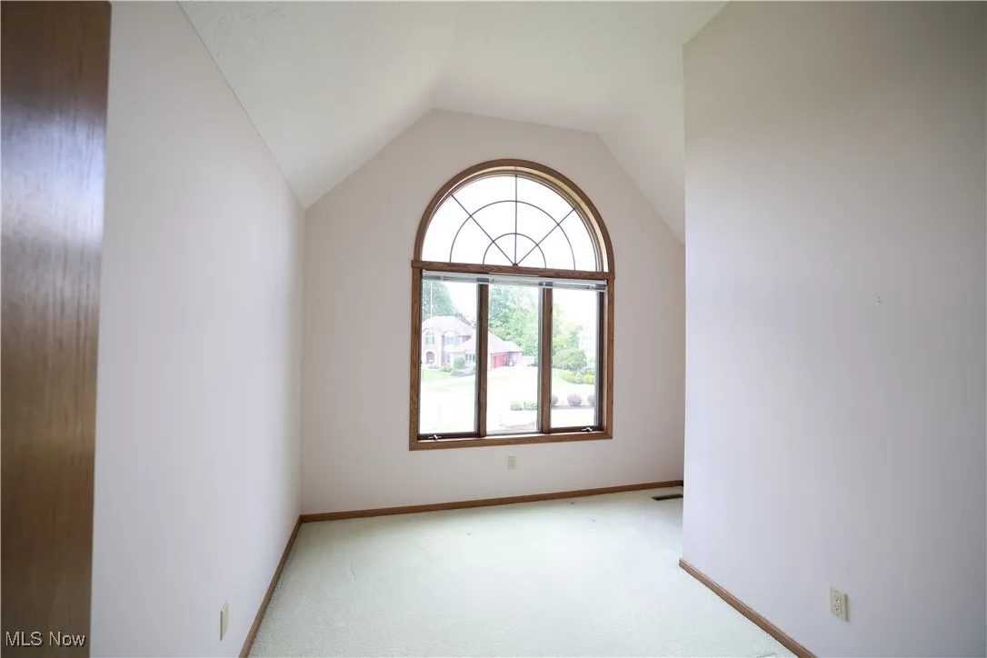 Bedroom featuring carpet flooring and vaulted ceiling