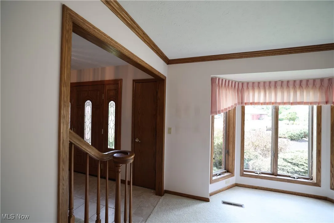 Entrance foyer with partial open staircase in living room