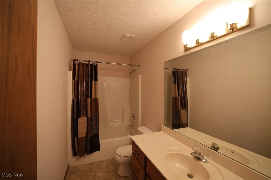 Second floor full bathroom featuring a textured ceiling, shower / bath combination and single vanity