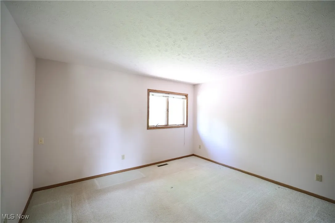 Bedroom with a textured ceiling and carpet floors