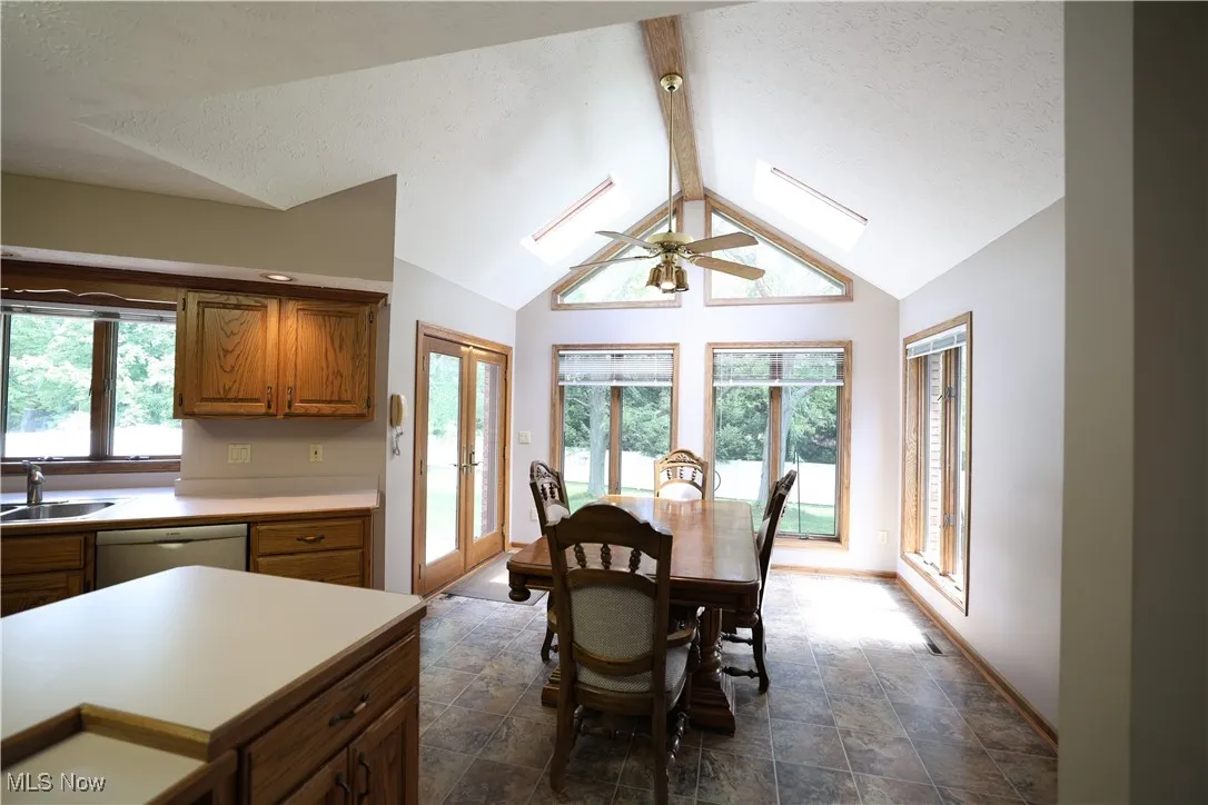 Dining space featuring a textured ceiling, French patio doors, plenty of natural light, and vinyl flooring