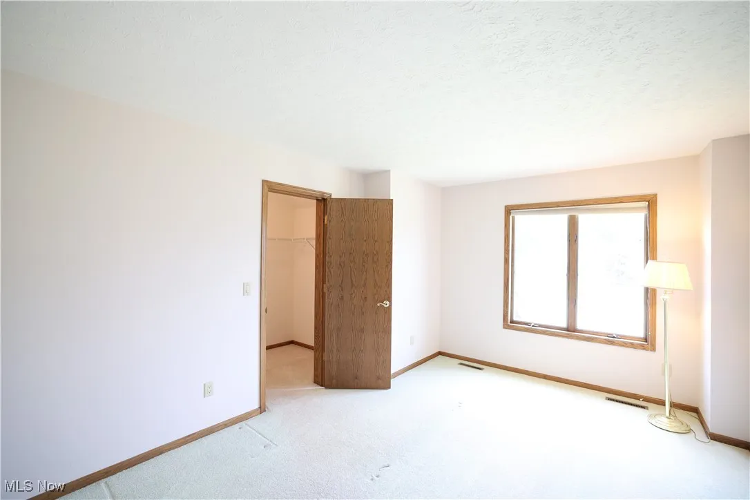 Bedroom featuring walk-in closet and carpet