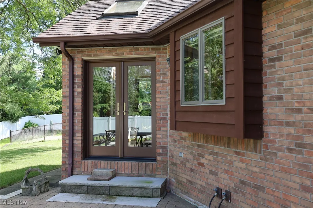 View of exterior entry with patio doors and brick siding
