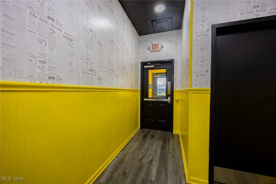 Hall with wainscoting and dark wood-style floors