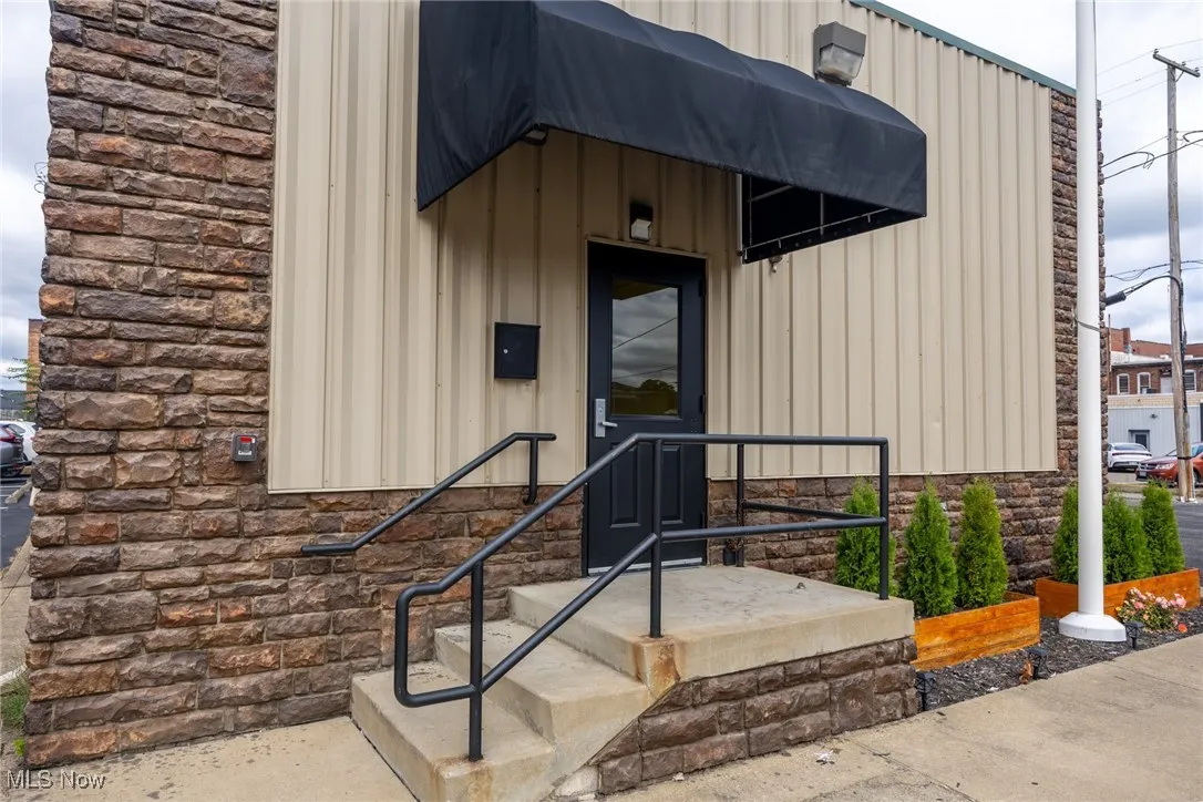 Entrance to property featuring board and batten siding and stone siding