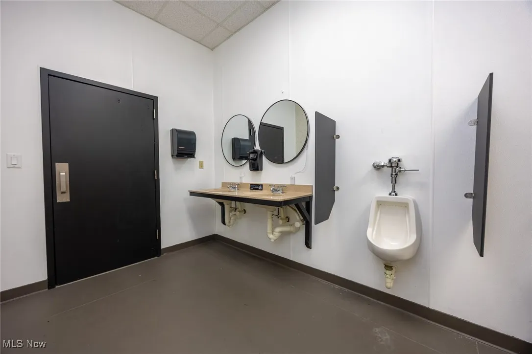 Bathroom featuring a paneled ceiling and finished concrete flooring