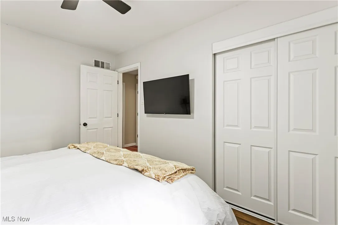 Bedroom featuring dark wood finished floors, ceiling fan, and a closet