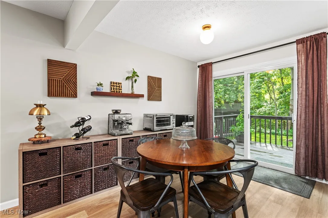 Dining space with light wood-style flooring and a textured ceiling