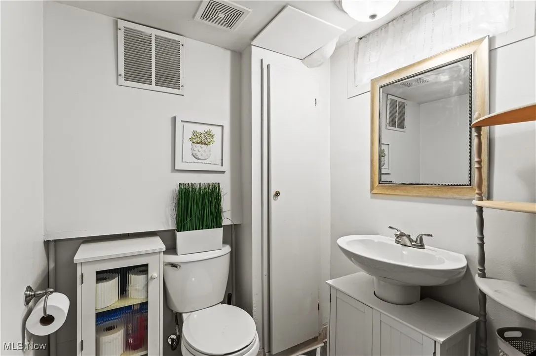 Half bathroom featuring vanity and toilet