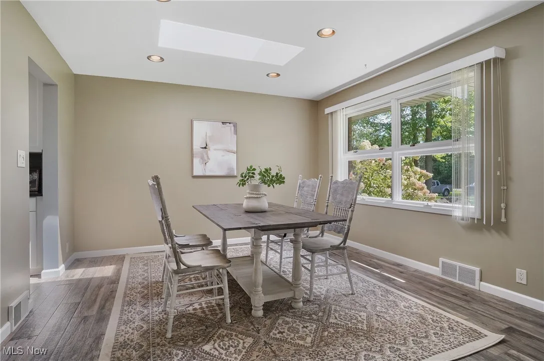 Dining area featuring a skylight, recessed lighting, and wood finished floors