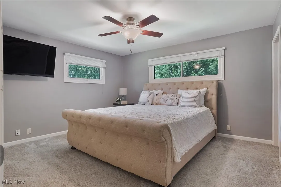 Bedroom featuring light colored carpet and ceiling fan