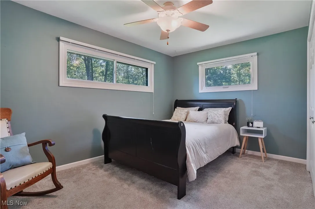 Carpeted bedroom featuring ceiling fan and baseboards