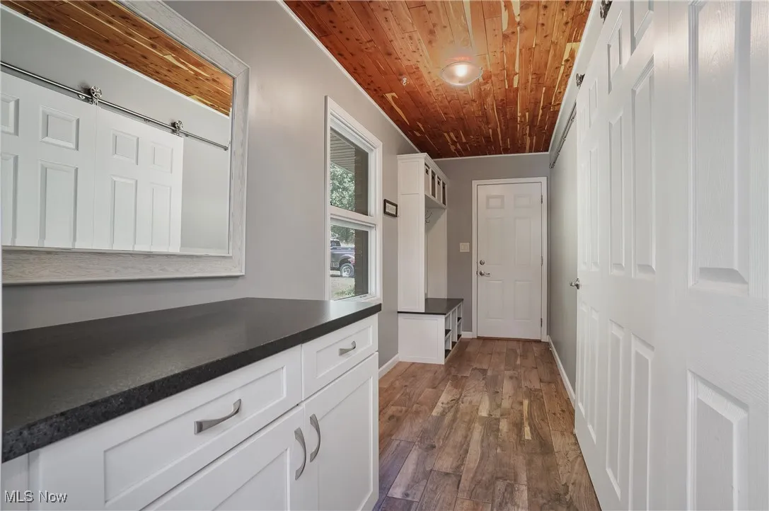 Hall with dark wood-style floors and wood ceiling