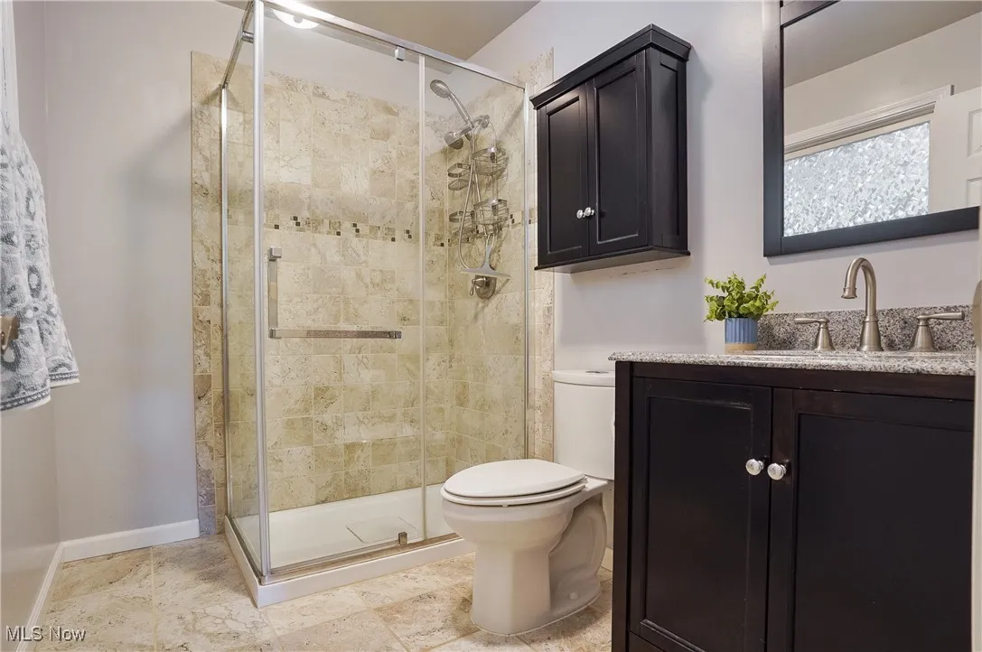 Bathroom featuring a shower stall and vanity