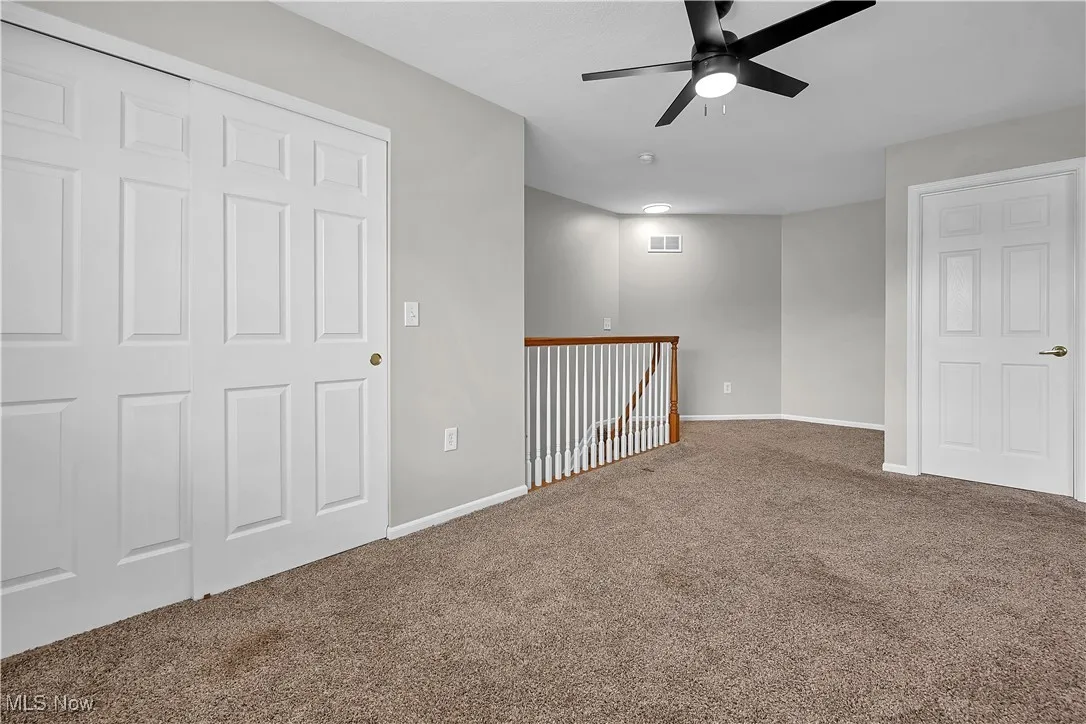 Spare room with ceiling fan and carpet floors