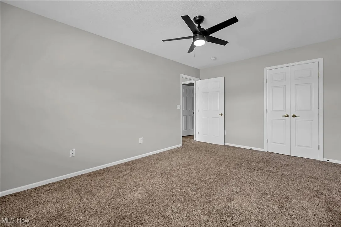 Unfurnished bedroom featuring carpet, a ceiling fan, and a closet