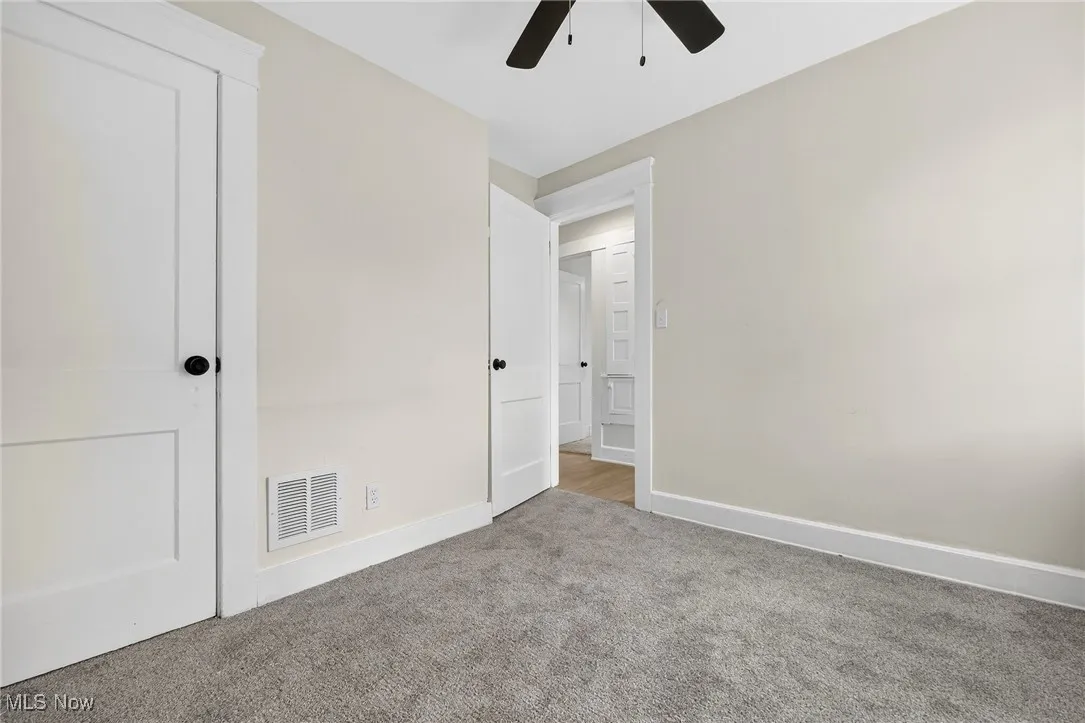 Unfurnished bedroom with carpet flooring and a ceiling fan