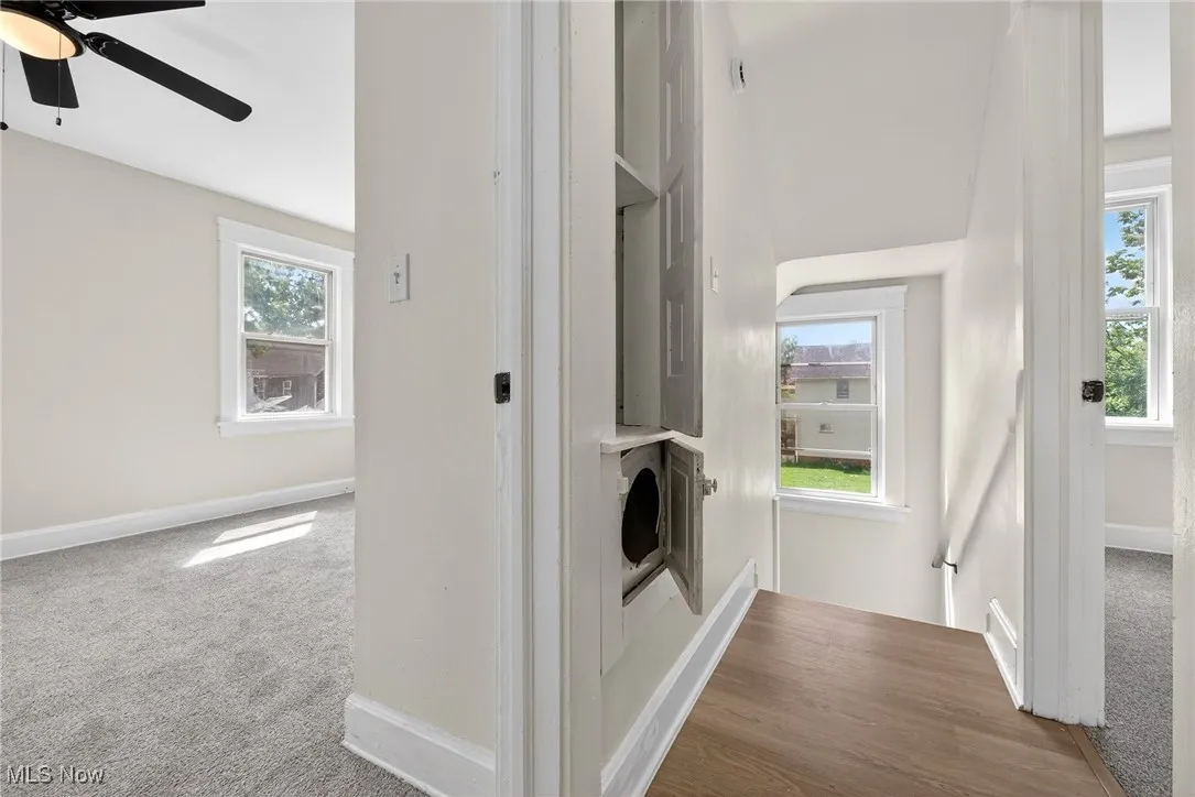 Corridor featuring carpet flooring and baseboards