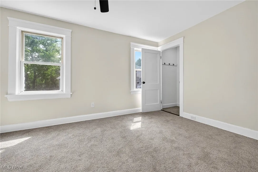 Carpeted empty room with baseboards and ceiling fan