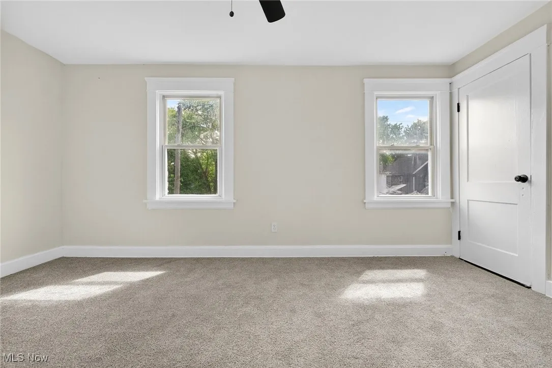 Empty room featuring carpet flooring and ceiling fan