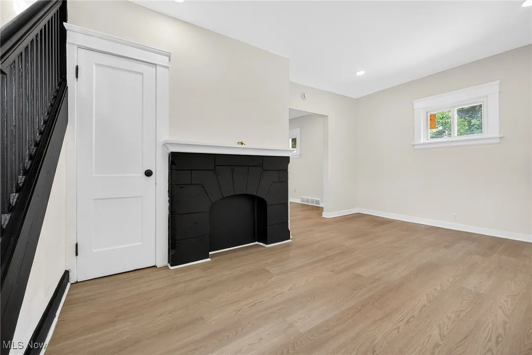 Unfurnished living room featuring light wood-type flooring, recessed lighting, and stairs