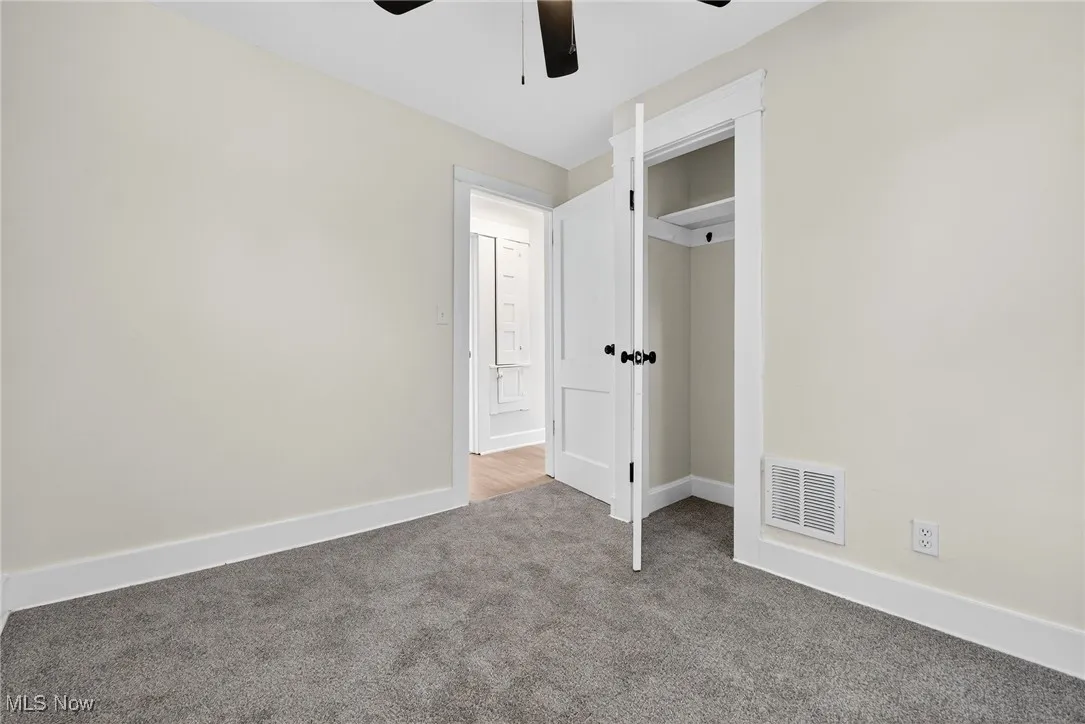 Unfurnished bedroom featuring carpet, a ceiling fan, and a closet