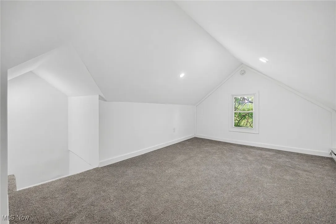 Bonus room featuring light carpet and vaulted ceiling
