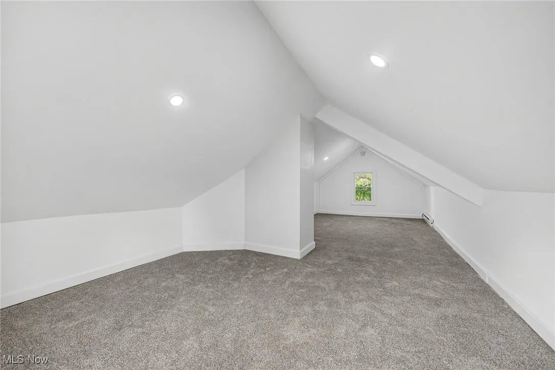 Additional living space with carpet, vaulted ceiling, and recessed lighting