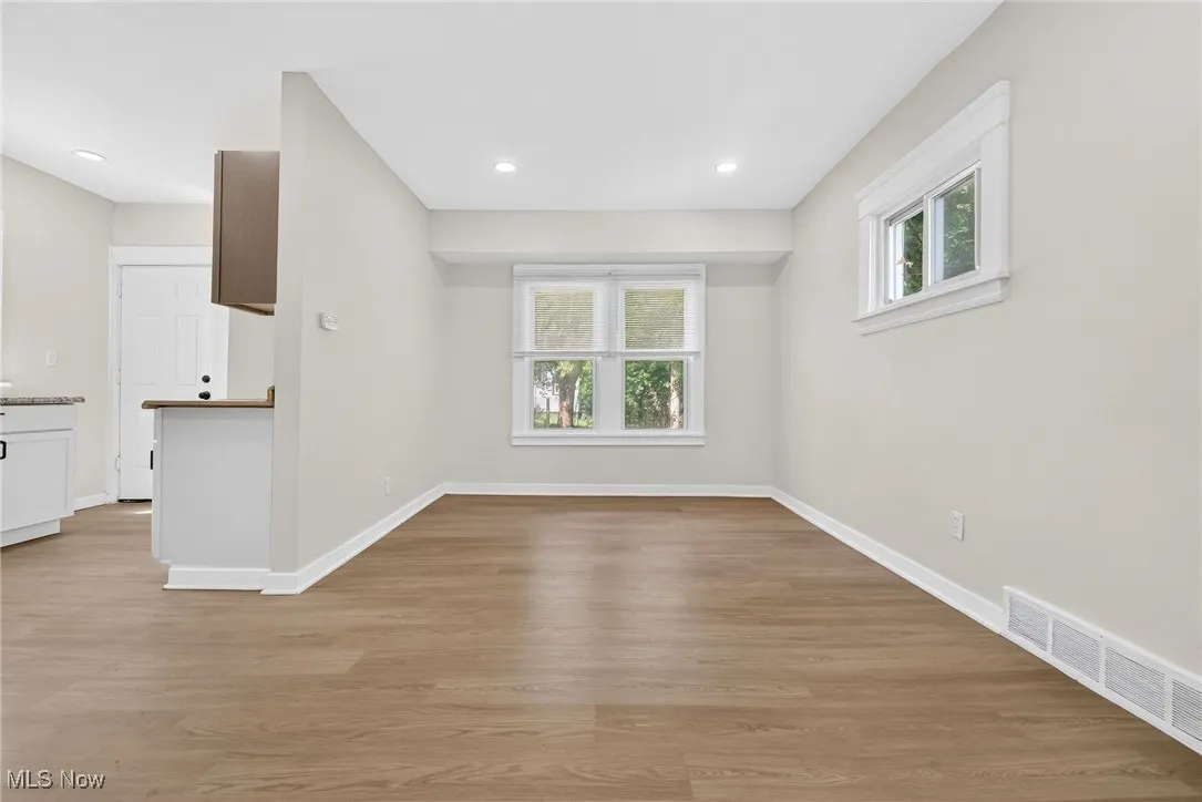Unfurnished living room featuring light wood finished floors, healthy amount of natural light, and recessed lighting