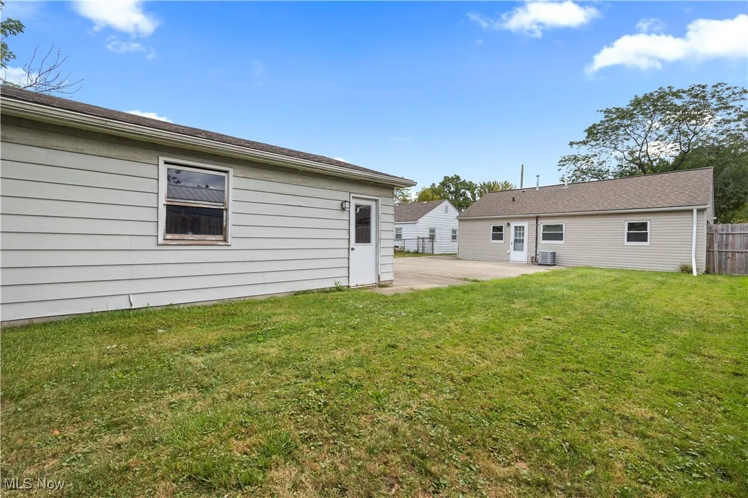 Rear view of house with a patio area and a yard