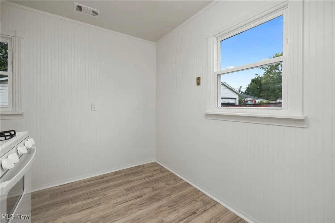 Unfurnished room with light wood-style flooring and ornamental molding