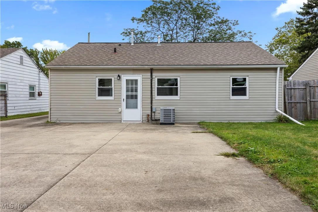 Rear view of house with a patio area and roof with shingles