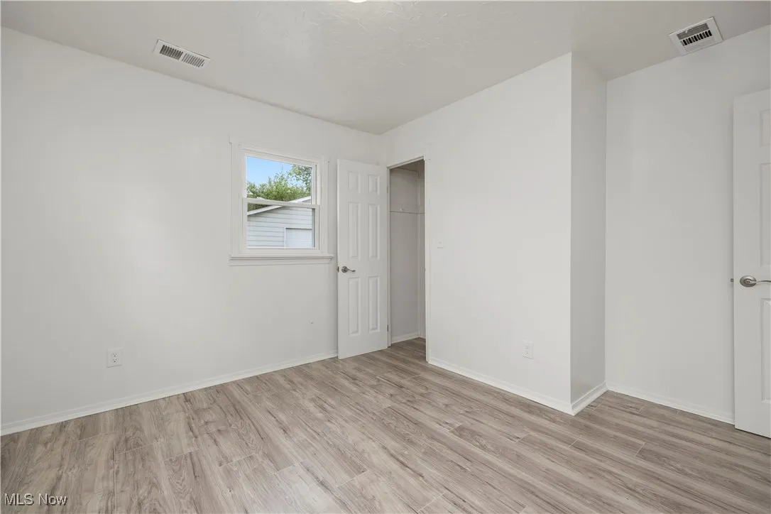 Unfurnished bedroom featuring light wood-type flooring and baseboards