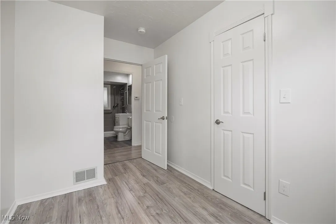 Unfurnished bedroom featuring light wood finished floors and baseboards