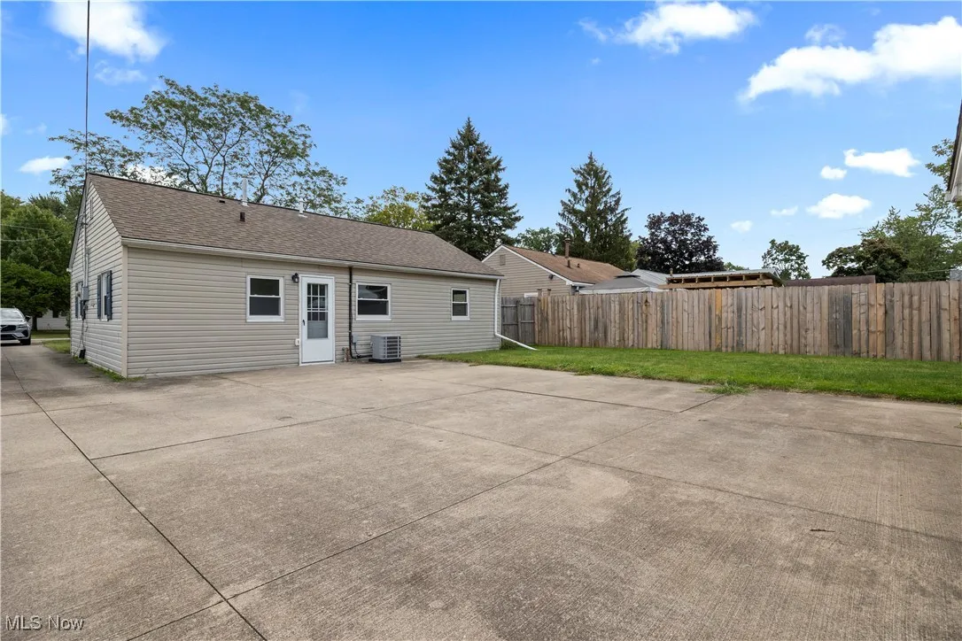 Rear view of property with a patio area and a shingled roof