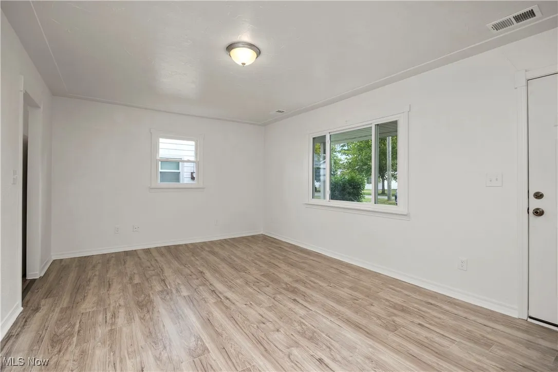 Empty room featuring light wood finished floors and healthy amount of natural light